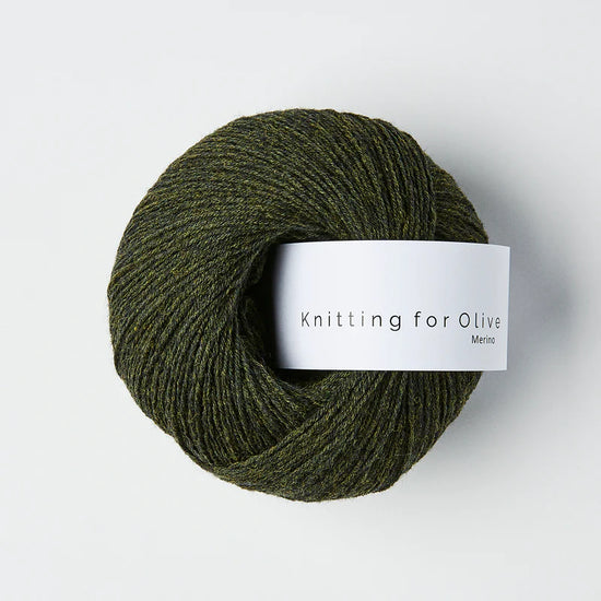 “Bol wol in de kleur ‘Slate Green’ van Knitting for Olive, uit de Merino-lijn, netjes opgerold met wit label tegen een witte achtergrond – zacht, ademend en duurzaam garen.”