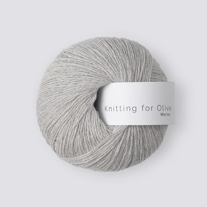 “Bol wol in de kleur ‘Pearl Gray’ van Knitting for Olive, uit de Merino-lijn, netjes opgerold met wit label tegen een witte achtergrond – zacht, ademend en duurzaam garen.”