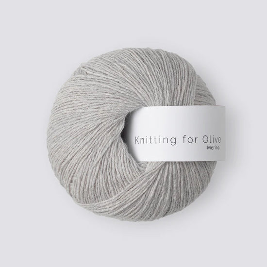 “Bol wol in de kleur ‘Pearl Gray’ van Knitting for Olive, uit de Merino-lijn, netjes opgerold met wit label tegen een witte achtergrond – zacht, ademend en duurzaam garen.”