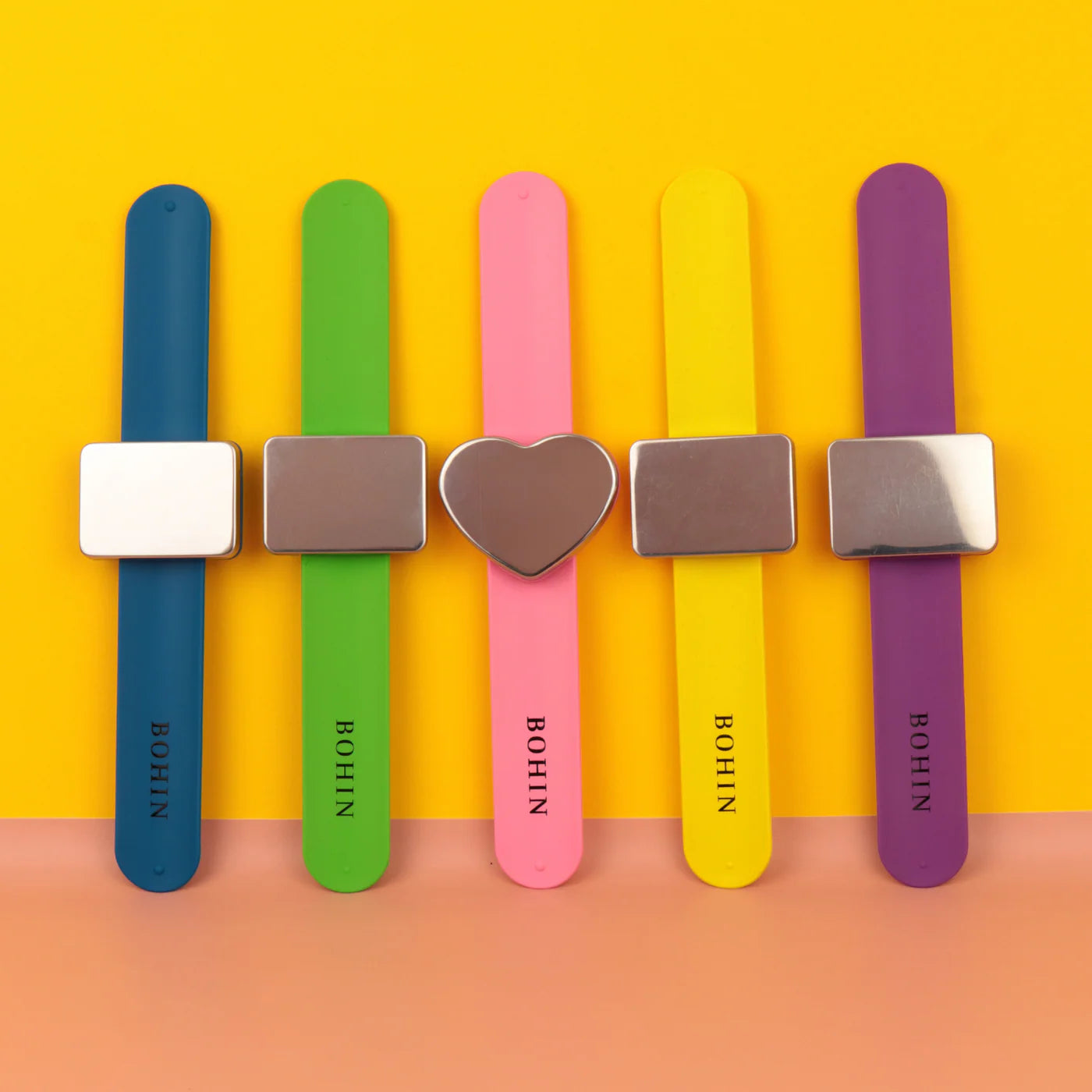 Magnetische armbanden van Bohin in blauw, groen, roze, geel en paars met hart- en rechthoekige magneetplaten.