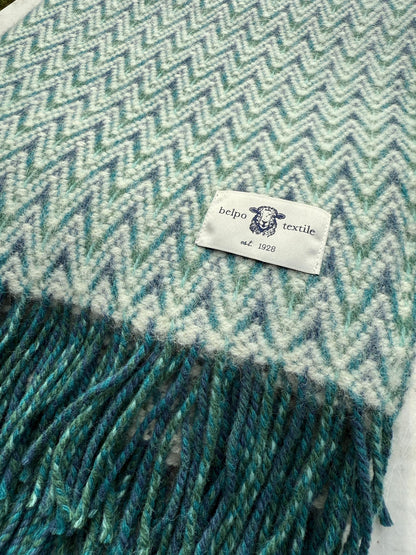 Close-up van het Belpo Waves Special Blue plaid, met zicht op het geweven zigzagpatroon in blauw en wit en het Belpo Textile-label met schaapje.