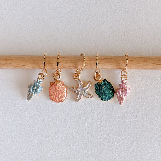 Kleurrijke steekmarkeerders van Hello Kim met schelpen en zeesterren, perfect voor zomerse breiprojecten.