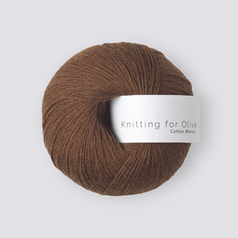 Bol wol in de kleur ‘Dark Cognac’ van Knitting for Olive, uit de Cotton Merino-collectie, netjes opgerold met een wit label en weergegeven tegen een rustige witte achtergrond – perfect voor zachte en tijdloze breiprojecten.