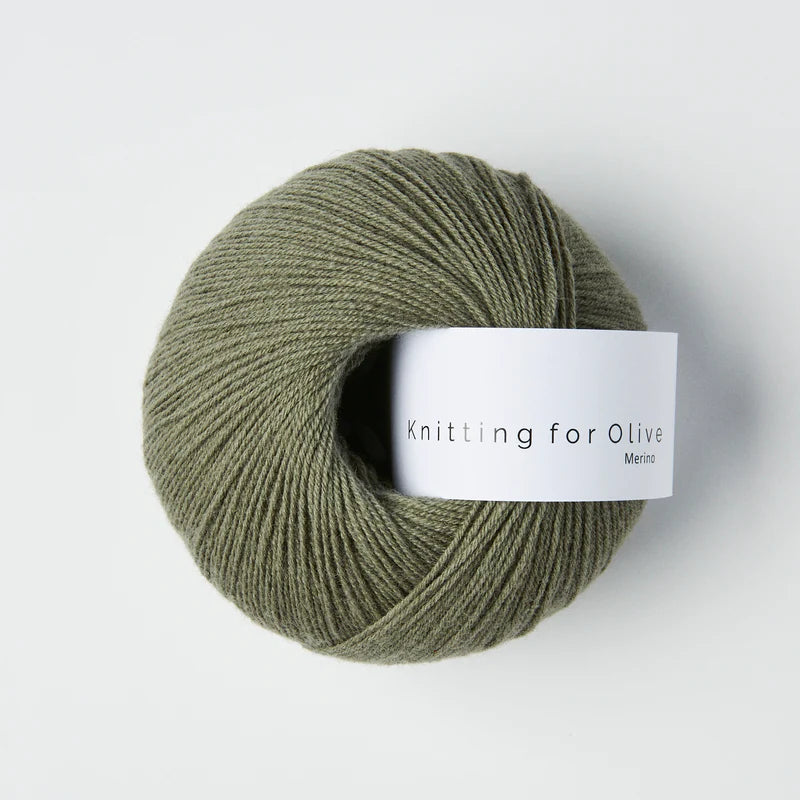 “Bol wol in de kleur ‘Dusty Sea Green’ van Knitting for Olive, uit de Merino-lijn, netjes opgerold met wit label tegen een witte achtergrond – zacht, ademend en duurzaam garen.”