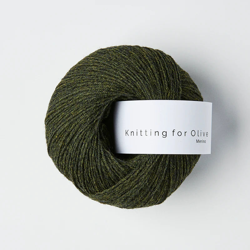“Bol wol in de kleur ‘Slate Green’ van Knitting for Olive, uit de Merino-lijn, netjes opgerold met wit label tegen een witte achtergrond – zacht, ademend en duurzaam garen.”