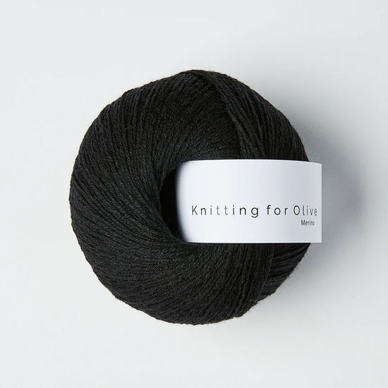 “Bol wol in de kleur ‘Licorice’ van Knitting for Olive, uit de Merino-lijn, netjes opgerold met wit label tegen een witte achtergrond – zacht, ademend en duurzaam garen.”