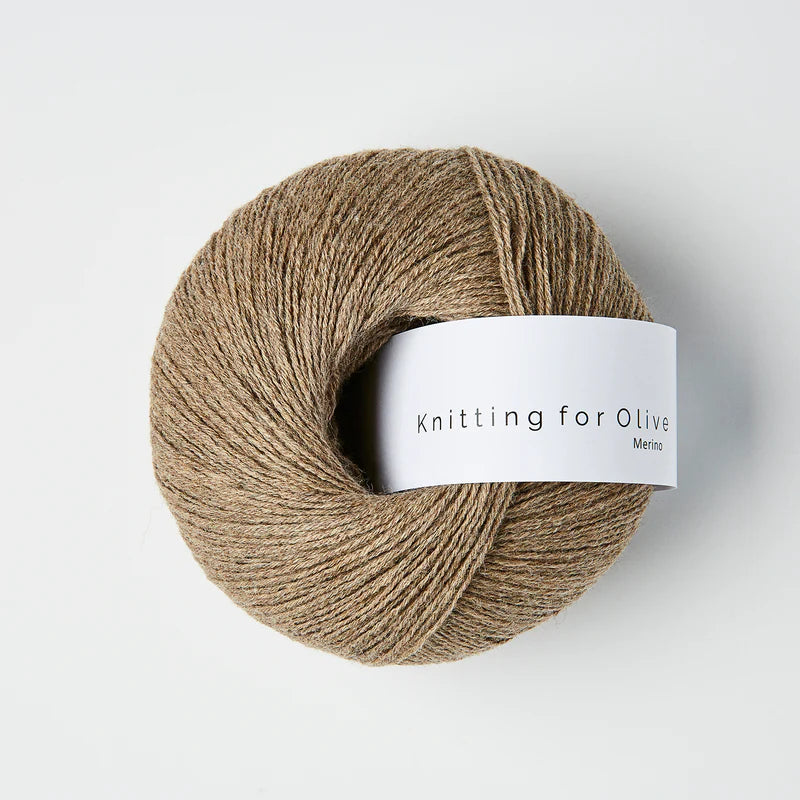 “Bol wol in de kleur ‘Cardamom van Knitting for Olive, uit de Merino-lijn, netjes opgerold met wit label tegen een witte achtergrond – zacht, ademend en duurzaam garen.”