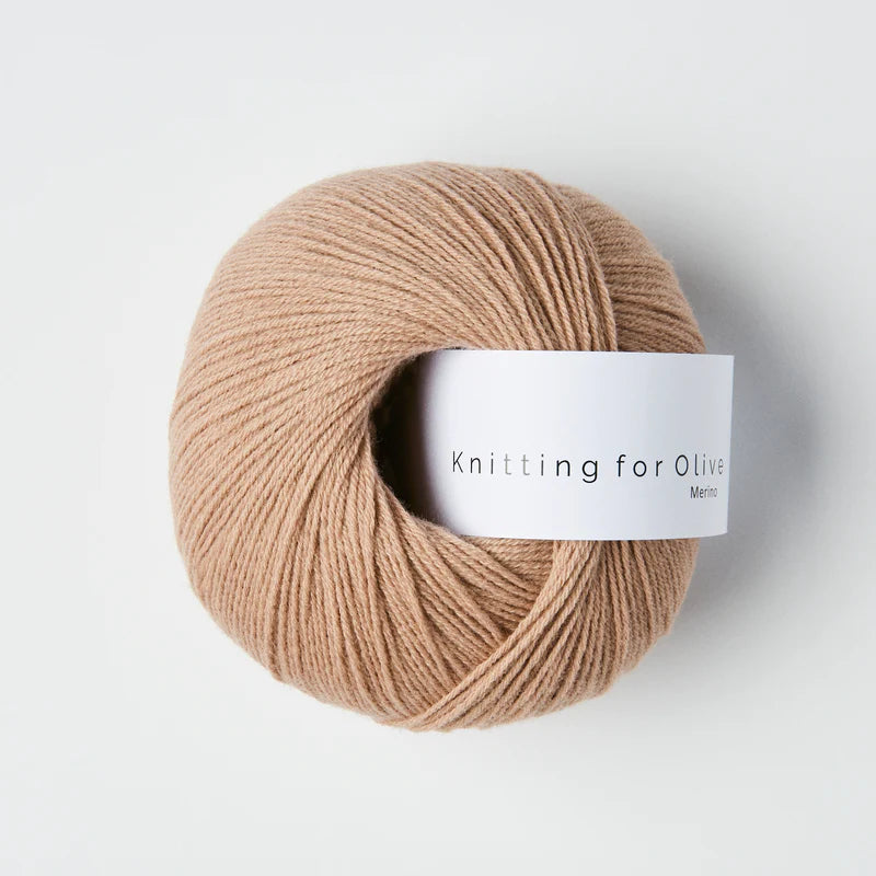 “Bol wol in de kleur ‘Mushroom’ van Knitting for Olive, uit de Merino-lijn, netjes opgerold met wit label tegen een witte achtergrond – zacht, ademend en duurzaam garen.”
