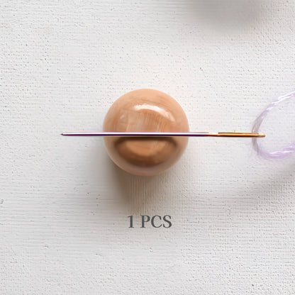 Bovenaanzicht van een houten Seeknit Magnetic Needle Keeper. Kleine ronde bol met ingebouwde magneet voor het veilig bewaren van naalden.