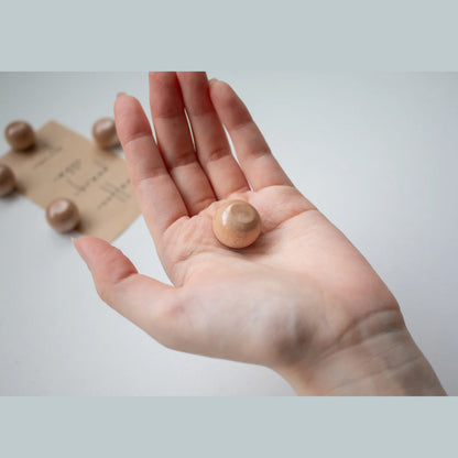 Hand houdt de Seeknit Magnetic Needle Keeper vast met een metalen naald erop. Compact hulpmiddel voor naaien en borduren.