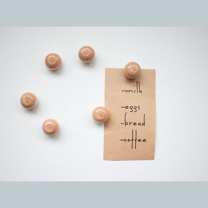 Meerdere houten Seeknit Magnetic Needle Keepers op een lichte ondergrond. Decoratief en praktisch accessoire voor handwerkprojecten.